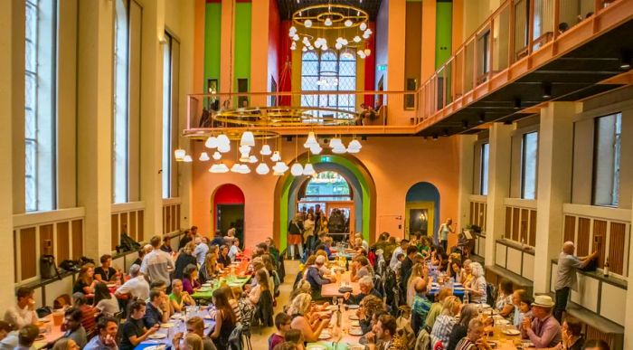 A vibrant scene at Absalon in central Copenhagen, Denmark, where diners enjoy communal meals together.