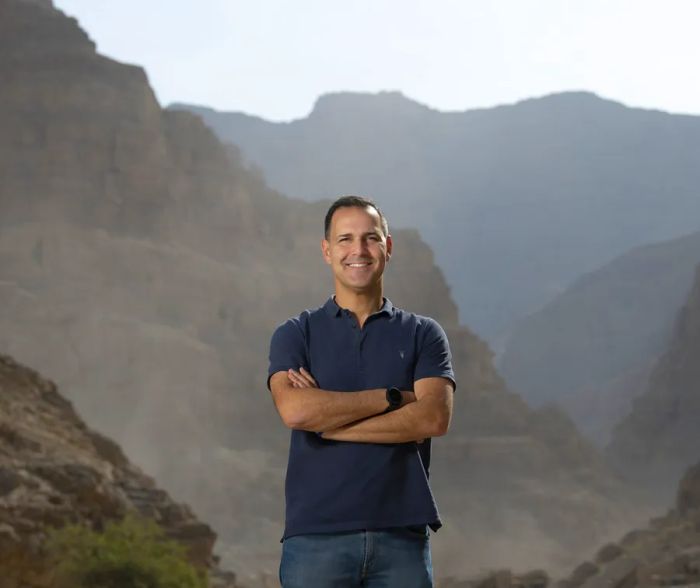 Raki Phillips, CEO of the Ras Al Khaimah Tourism Development Authority, poses against a backdrop of mountains.