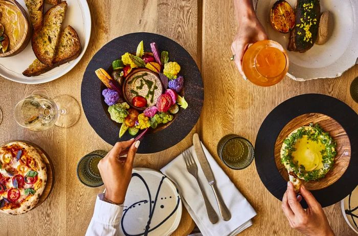 An aerial view of dishes presented on white or black plates at Yaya restaurant