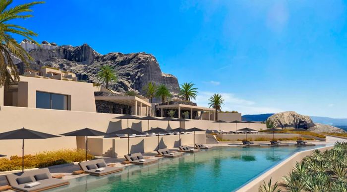 The primary pool at Santo Mine Oia Suites features gray chaise longues lining its edges, offering a stylish relaxation spot.