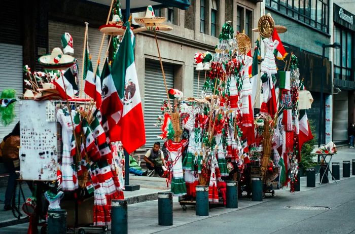 Various sizes of Mexican flags available for purchase along a street