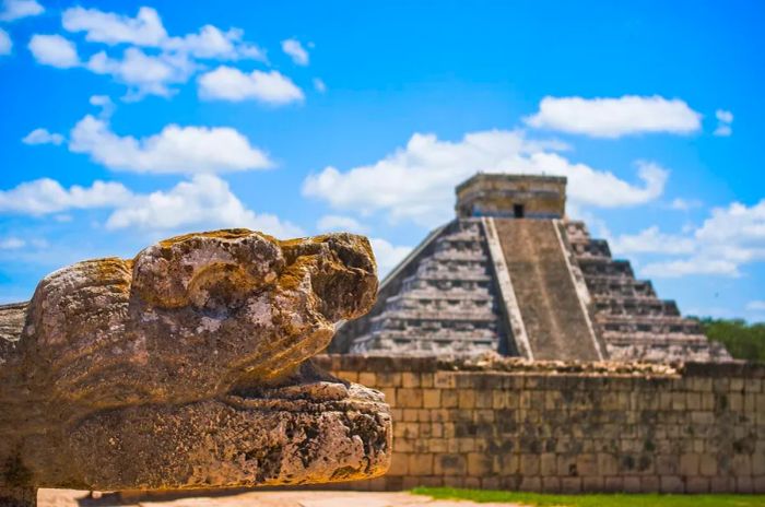 A stone animal sculpture beside an ancient pyramid