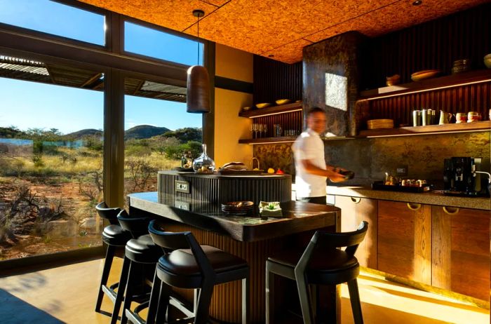 Interior view of a kitchen in a Loapi villa, complete with a chef in a white shirt.