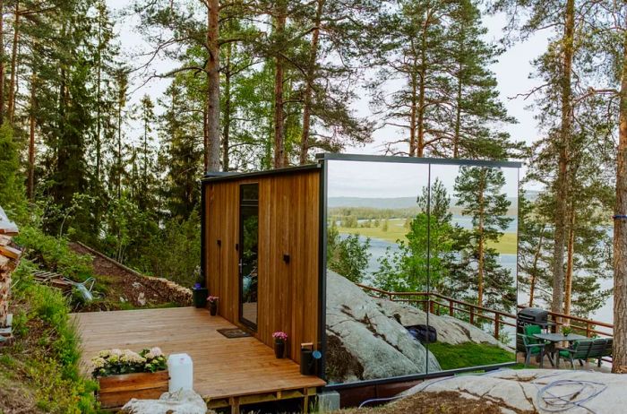 Exterior of a modern wooden cabin with a mirrored wall in the Norwegian woods