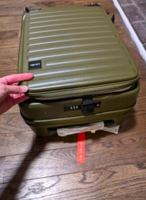 Closed olive green Lojel Cubo Small hardcase carry-on suitcase resting on a wooden floor