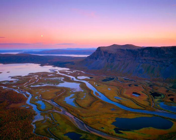 A bird's-eye view capturing rivers and mountains at sunset in Sarek National Park, Sweden.