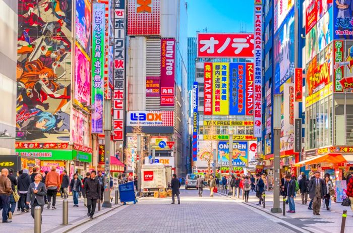 Crowds bustle beneath vibrant signs in Akihabara. This historic electronics hub has transformed into a shopping haven for video games, anime, manga, and tech gadgets.