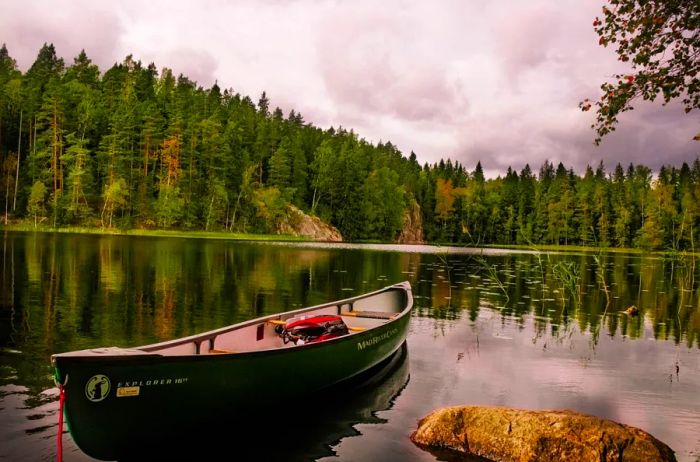 A tranquil lake with a small rowboat nestled amidst the forests of Finland