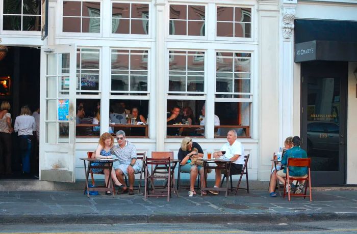 People enjoying outdoor dining at a restaurant near Market Street in Charleston