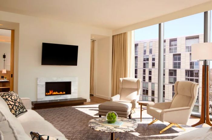 The Diplomat Suite at Conrad Washington, D.C. boasts a roomy sitting area complete with a fireplace and expansive floor-to-ceiling windows.