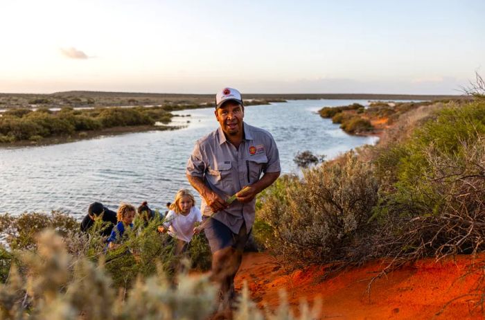 A guide leading a tour group uphill in Shark Bay, Australia