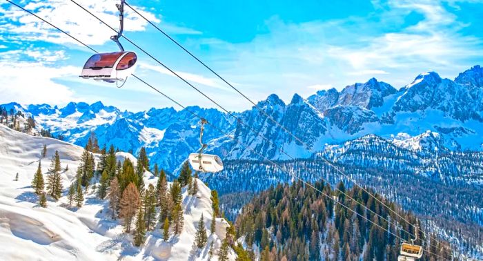 A winter scene in the Dolomites at the Cortina D'Ampezzo ski resort, featuring the Monte Castello area and chair lift installation.