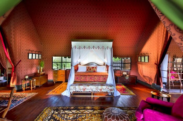 Inside a luxurious tent featuring silk walls and a four-poster bed at Jack's Camp