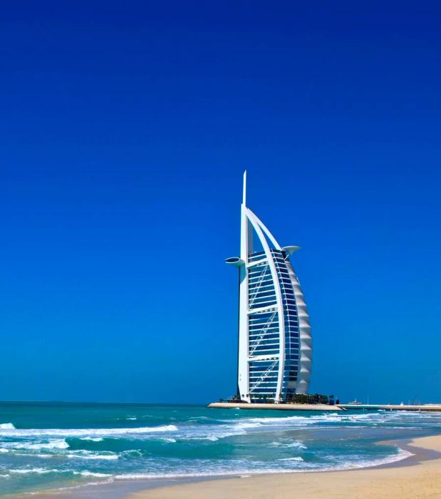 An exterior view of the Burj Al Arab with the beach stretching in front