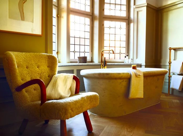 A bathroom featuring a tub positioned in front of a window at Ett Hem in Stockholm