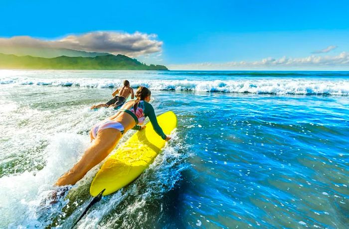 Couple surfing at Hanalei Bay, Hawaii