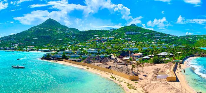 A beach nestled against towering green mountains.