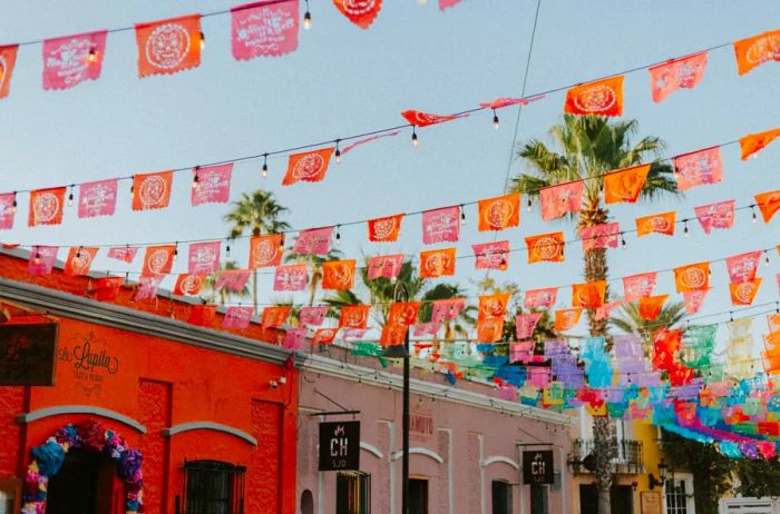 Vibrant buildings adorned with strings of small, colorful cutout flags above