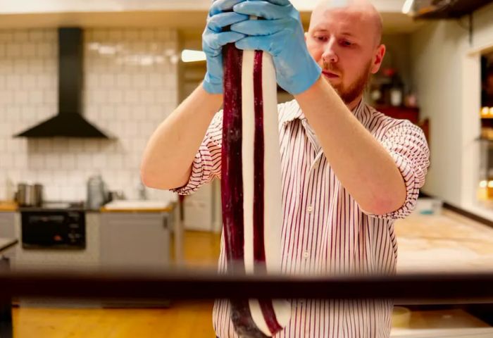 A person holding a red and white striped candy