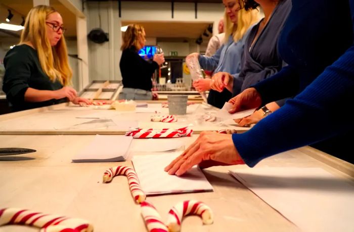 Visitors gathered at a counter crafting candy canes