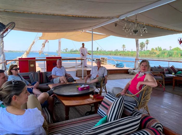 Six guests enjoying the fresh air on the top deck beneath a canopy