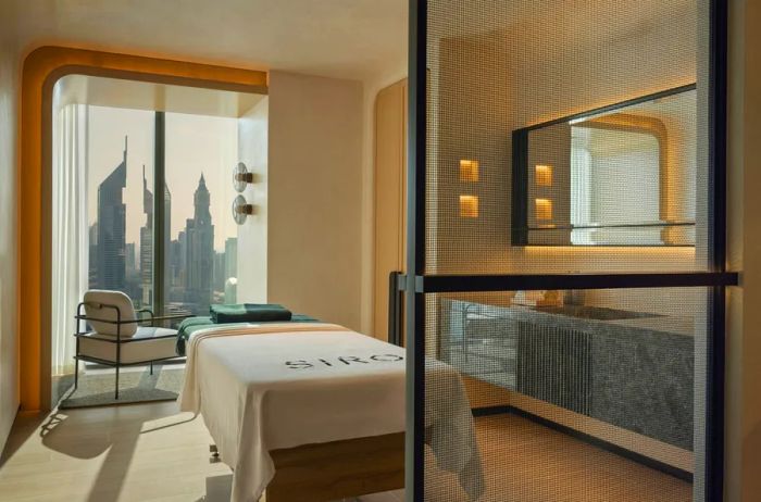 A recovery suite featuring a massage table with views overlooking the Dubai skyline.