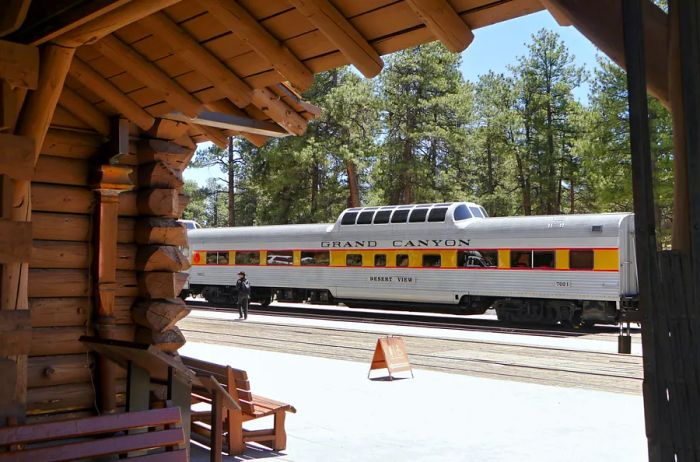 A gray railcar seen from a wooden station.