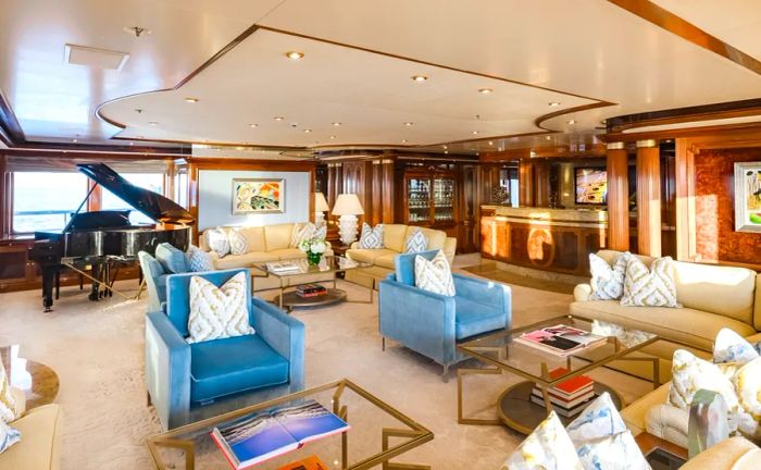 Living room area on the Titania yacht, showcasing a grand piano and multiple couches and armchairs