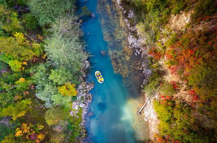 Aerial view of a raft gliding down a river through the forests of Bosnia and Herzegovina