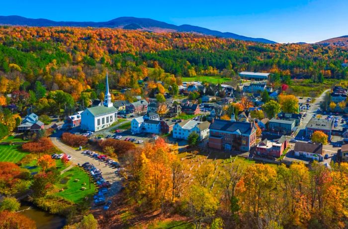 Aerial view of the charming town of Stowe, surrounded by vibrant autumn foliage.