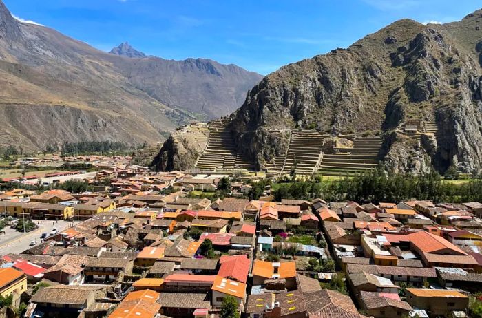 Aerial view of Ollantaytambo featuring ruins and the majestic Andes mountains in the background