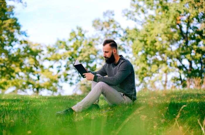 man reading a book in the park