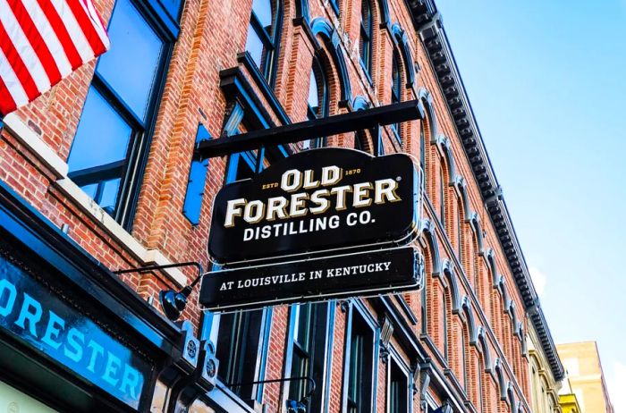 A classic Old Forester sign affixed to a brick building.