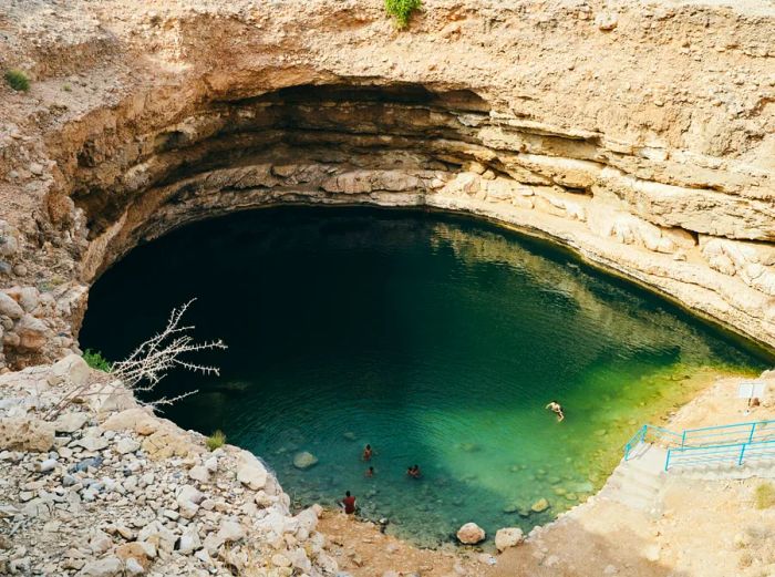 Aerial view of Bimmah Sinkhole, featuring a few swimmers.