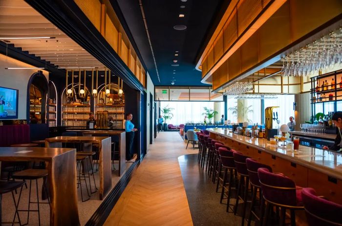 The softly lit interior of the Boston Chase Sapphire Lounge by the Club, featuring a long, empty bar.