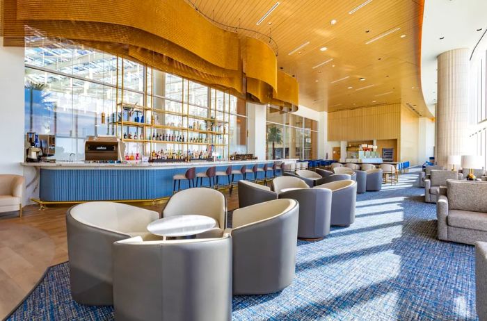 The bar area of the Plaza Premium lounge at Orlando International features rounded modern chairs in the foreground.