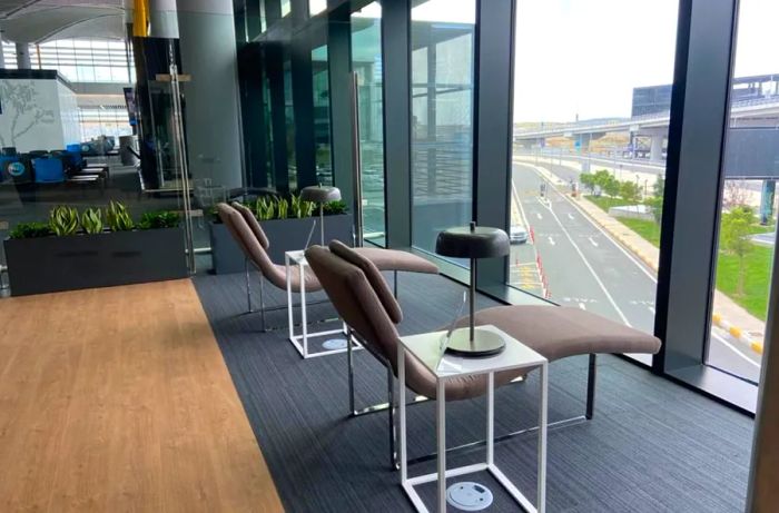 Two gray lounge chairs positioned in front of a window at the IGA Lounge in Istanbul International.