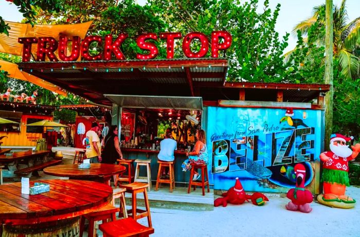 Patrons enjoying drinks at a bar named Truck Stop in San Pedro, Belize