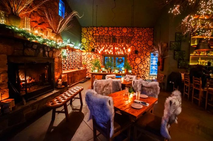 The dining area at Earth at Hidden Pond in Maine, featuring a fireplace and wooden decor