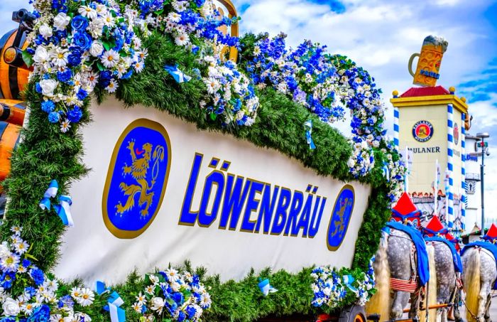 A horse-drawn wagon from Löwenbräu brewery, adorned with barrels of beer and surrounded by greenery and daisies.