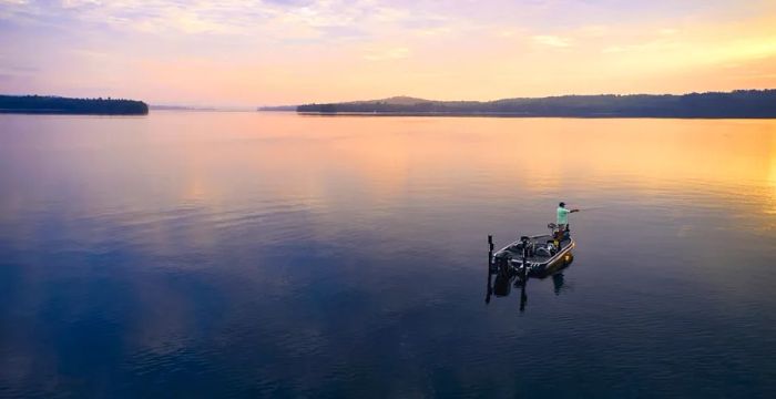 An individual fishing at sunset in Belgrade Lakes, Maine