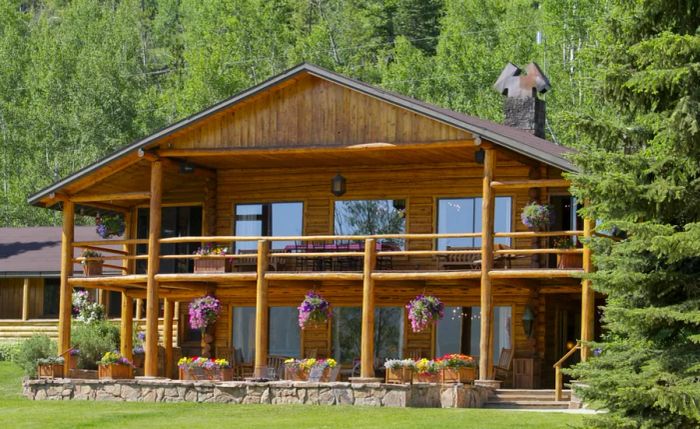 The two-story main lodge at C Lazy U Ranch, constructed from logs sourced from the property, features a welcoming balcony.