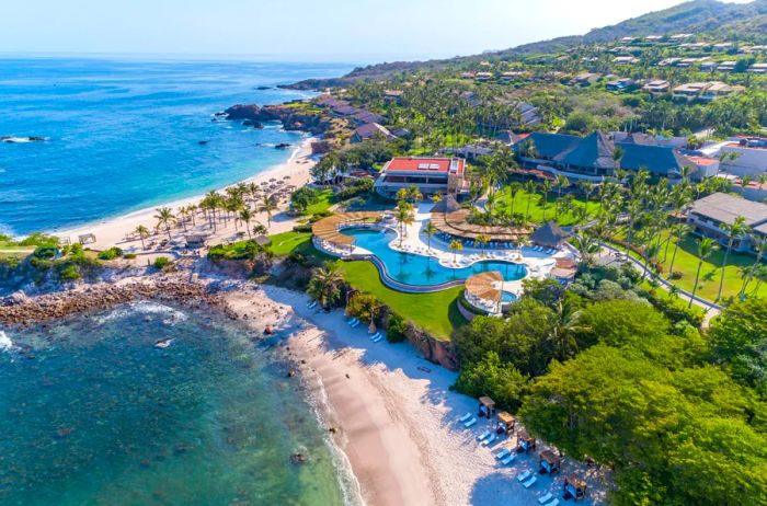 Aerial view of the Four Seasons Resort Punta Mita, showcasing a large, winding pool above the beaches.