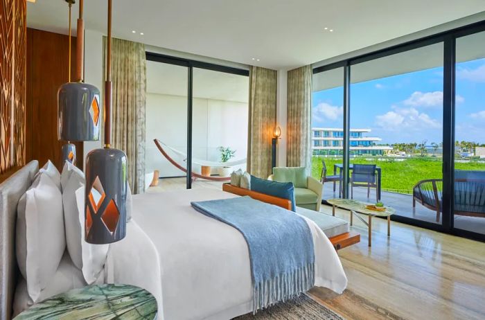 The interior of a guest room at St. Regis Kanai Resort showcases modern decor and expansive glass walls.