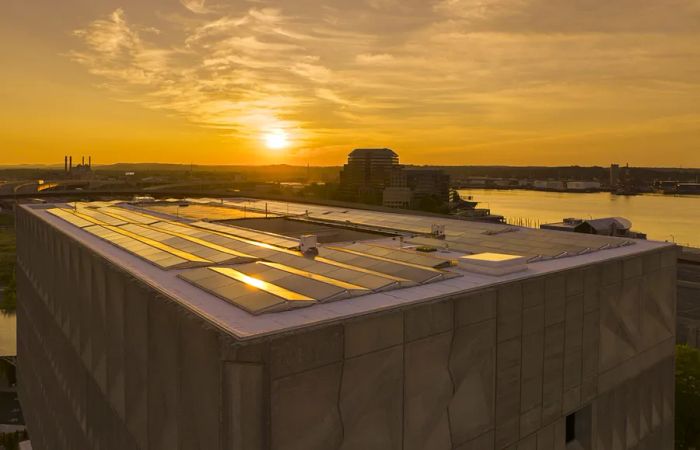 Hotel Marcel's rooftop solar panels illuminated by sunset