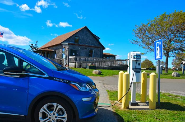 A blue vehicle charging at the EV station in Hammonasset State Park