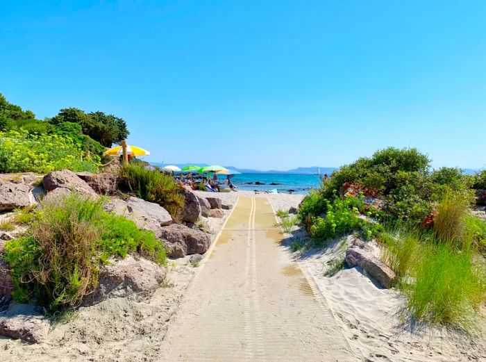 A two-lane road leading down to a beach.