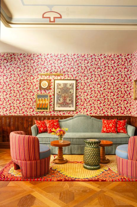 This room at Le Grand Mazarin showcases striped chairs, patterned wallpaper, and wooden flooring.