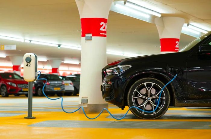 Electric vehicle charging station in a parking facility