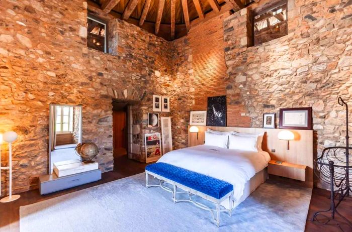 Interior view of the Lune Suite at Domaine des Etangs, showcasing its impressive high stone walls.